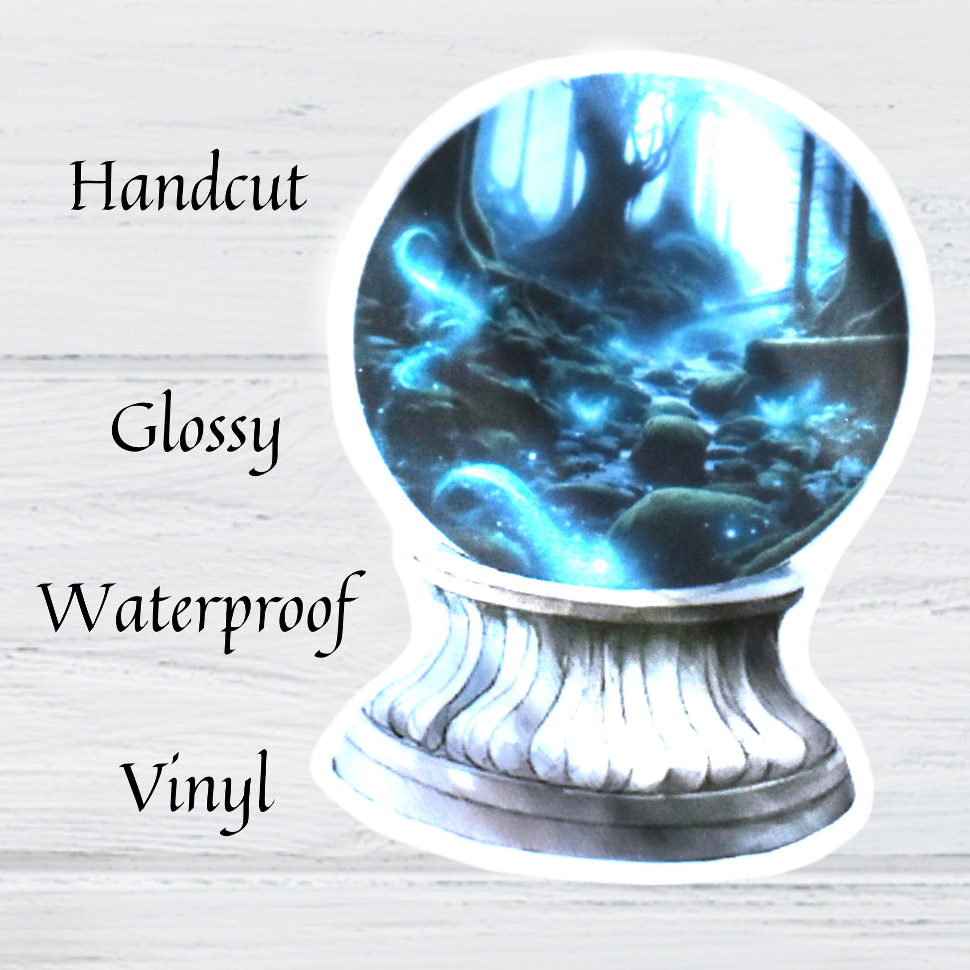 Decorative waterproof vinyl sticker with a fantasy scene in a crystal ball on a light wooden background.