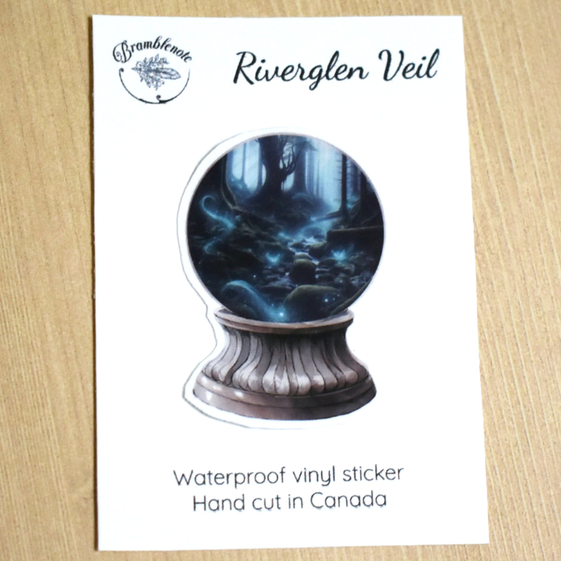 Riverglen Veil crystal ball sticker featuring a glowing stream winding between shadowed trees, fantasy night forest scene.

